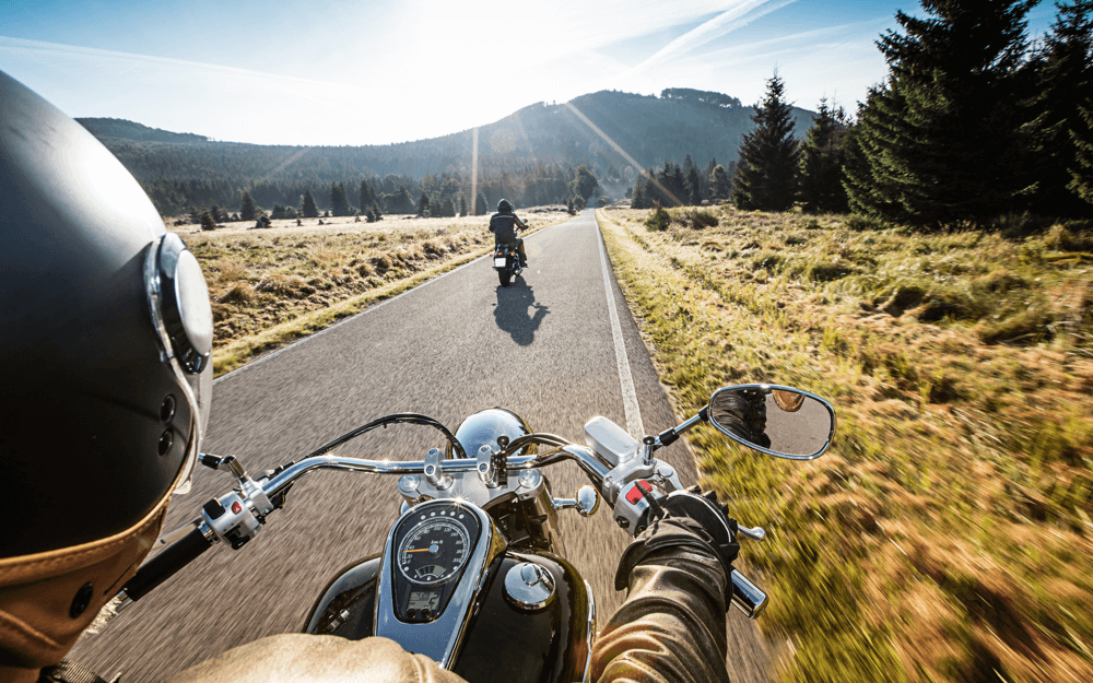 Rider's perspective on a motorcycle journey, following another rider through a scenic route